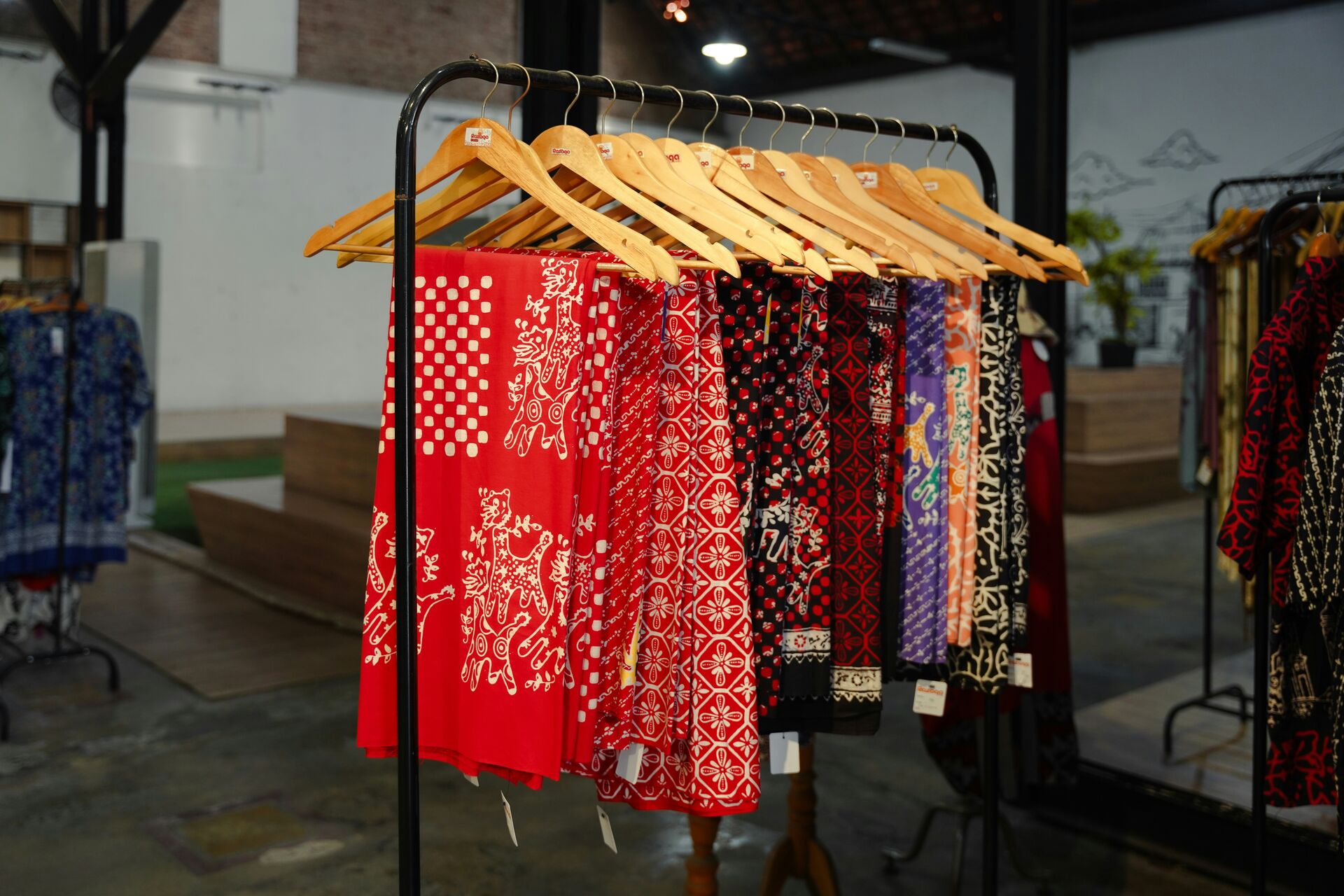 Colorful patterned fabrics hang on a rack